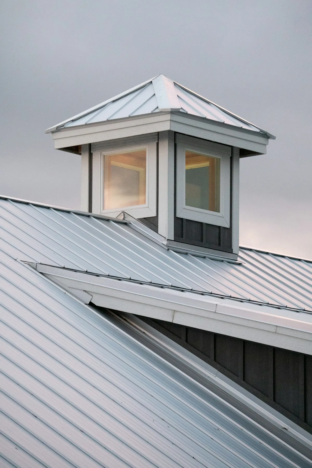 Silver standing seam roof with a windowed cupola