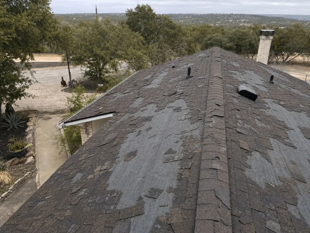 Asphalt roof missing shingles after a wind storm